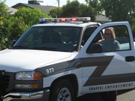 Traffic Enforcement Aide by her work vehicle.