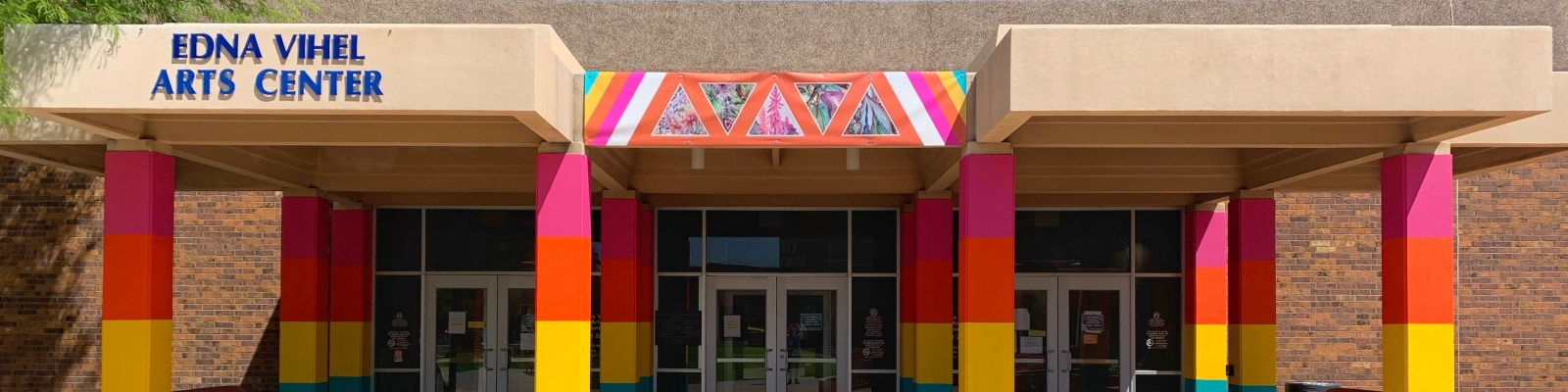 Image of a building with colorful pillars and the name 