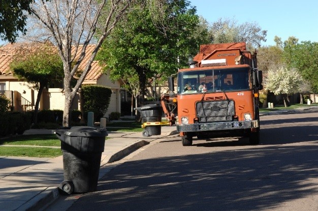 Orange garbage truck in neighborhood