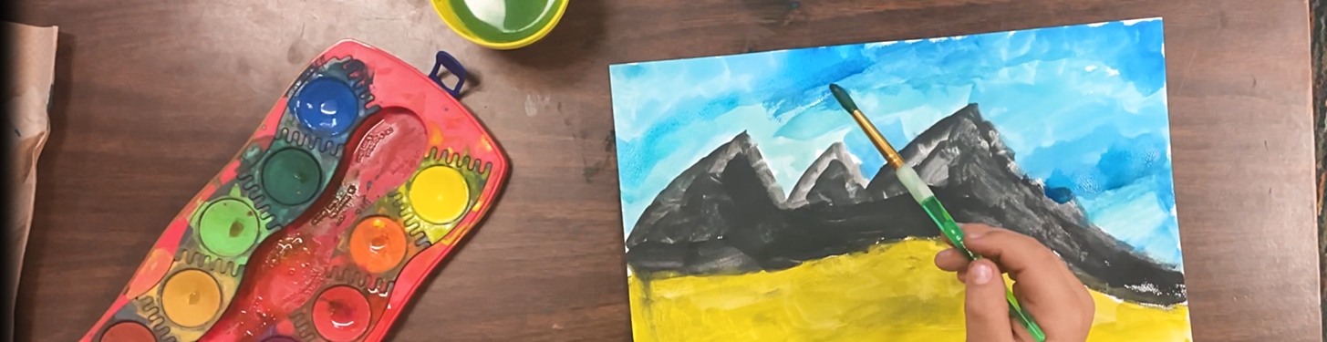 Child painting a mountain scene