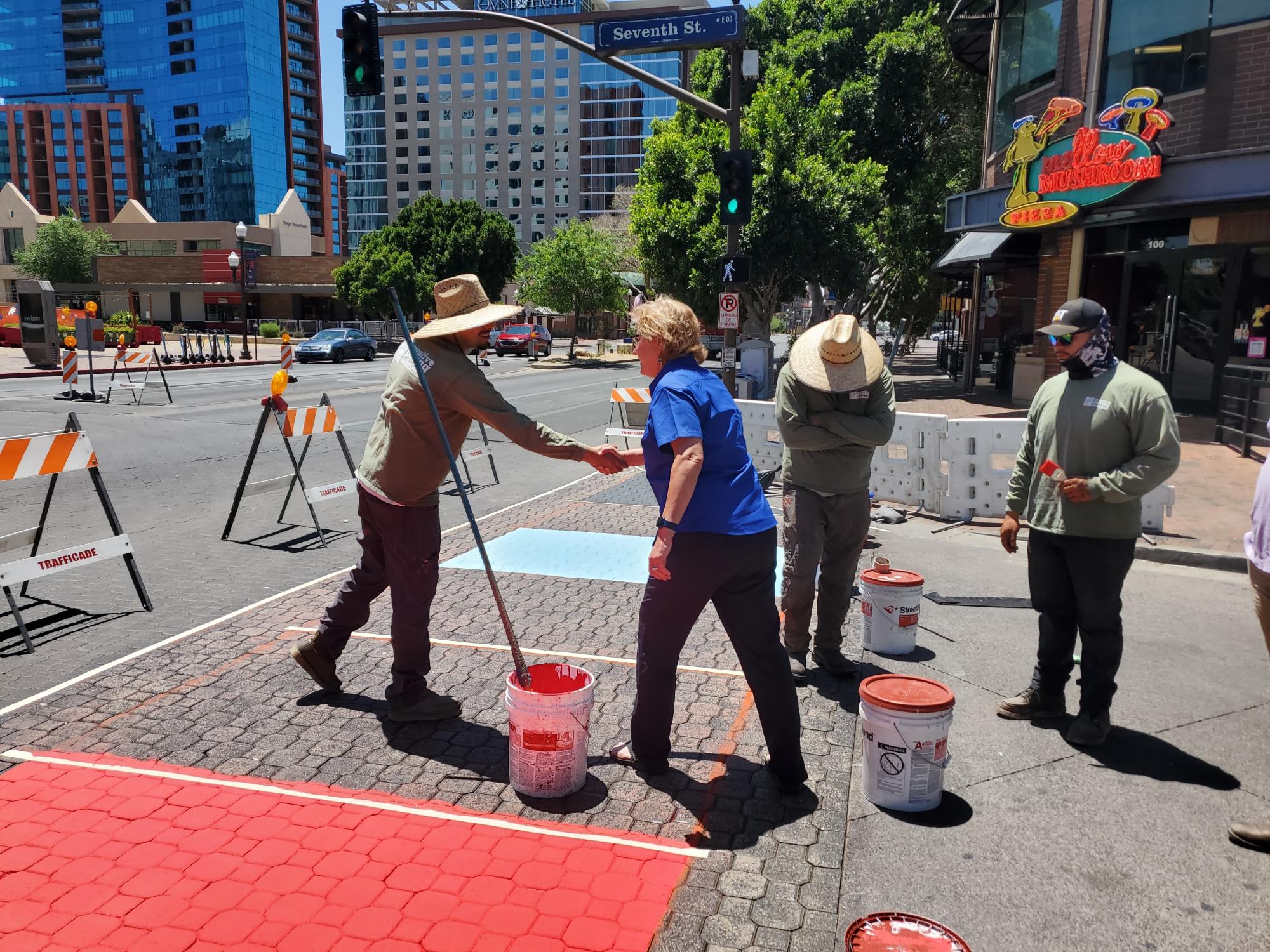 Councilmember Jennifer Adams thanks workers painting the Pride crosswalk on Mill and 7th