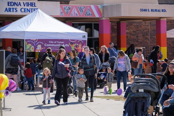 A crowd of people mingle around a tent