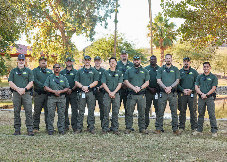 Group photo of Park Rangers in uniform standing in front of pond at Papago Park