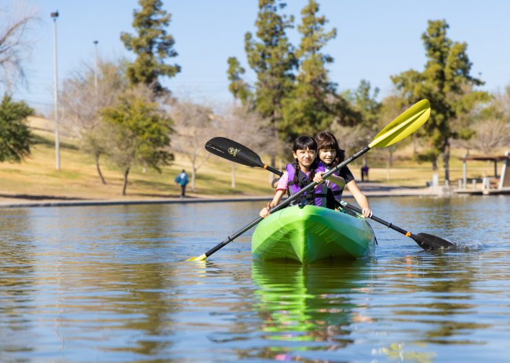 Two girls with paddles in kayak on Kiwanis Lake