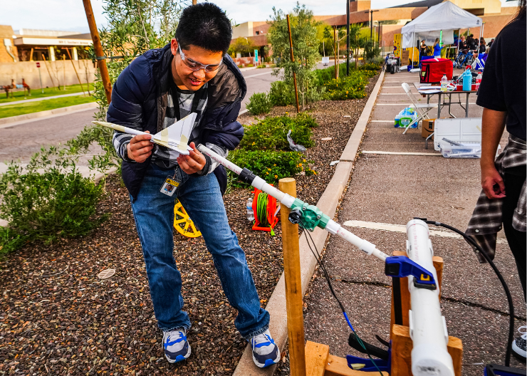 Teen holds rocket ship ready to launch it at Geeks Night Out